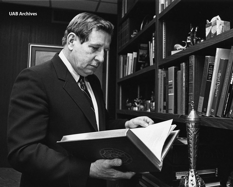 man reading book in library