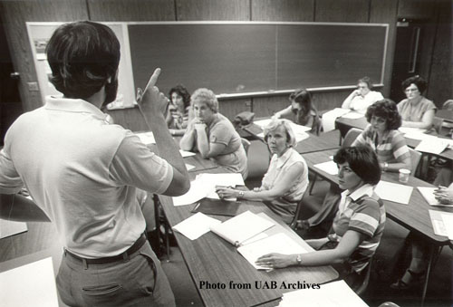 A professor lectures in front of a classroom