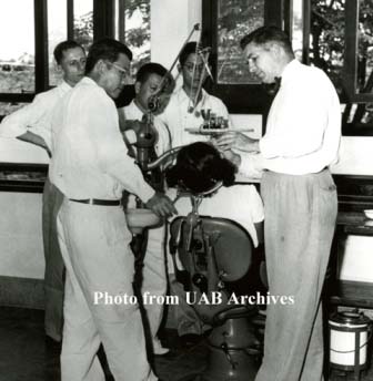 Students watch a dental procedure being done by an instructor