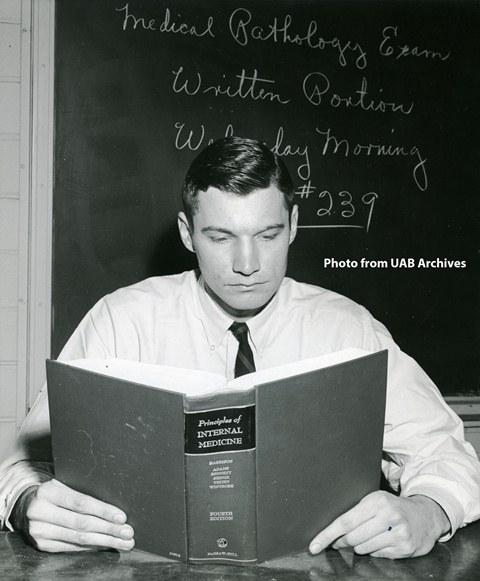 A male medical student reads from a textbook