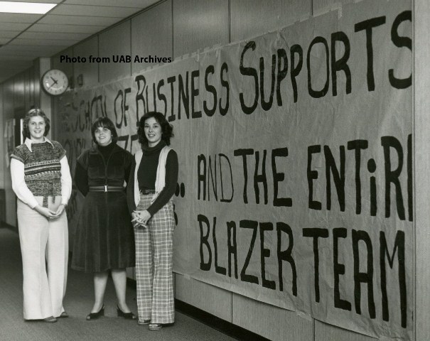 Three female students stand in the hallway