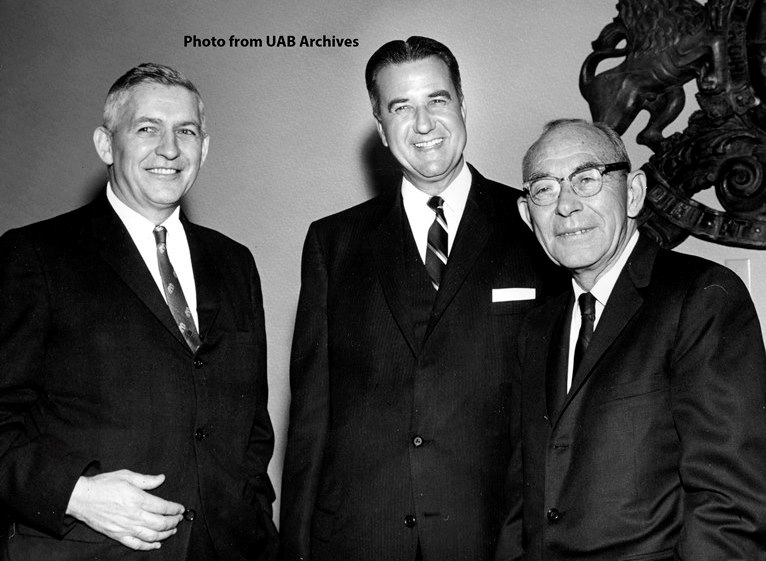 Three men smile at the camera