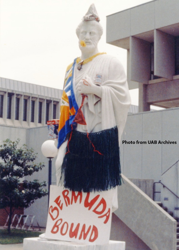 Hippocrates statue dressed in a blue grass skirt with a Bermuda bound sign