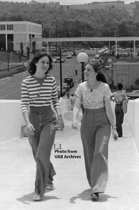 Two female students walk across the pedestrian bridge