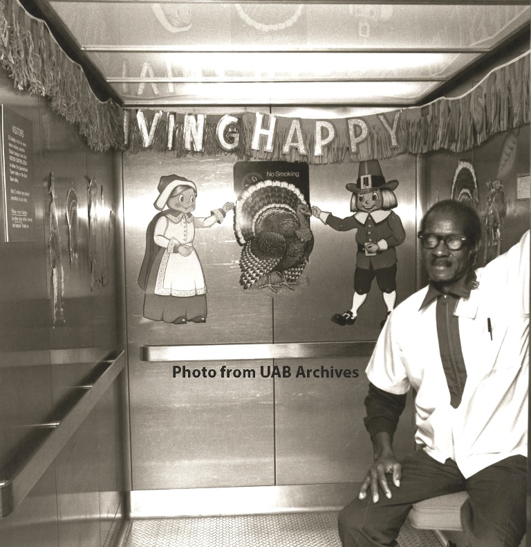 A man sits inside an elevator decorated for Thanksgiving